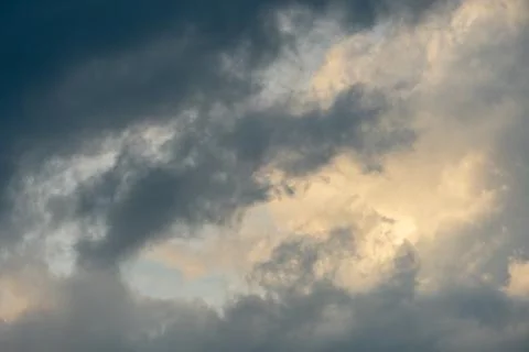 Gray clouds are lit by the setting sun. The sky after the rain. Stock Photos