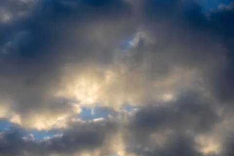 Gray clouds covering the sun during sunset Stock Photos
