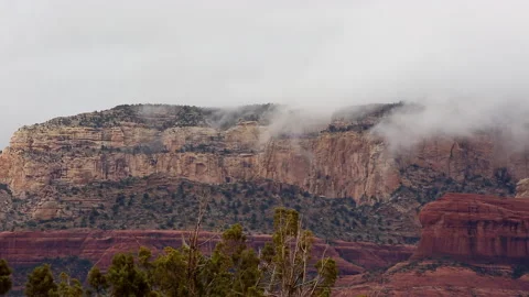 Gray clouds flow over the red rocks in the desert outside of Sedona, Arizona Stock Footage 146668828