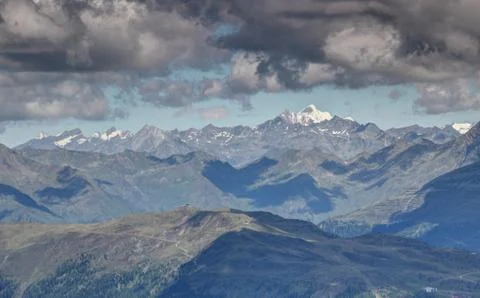 Gray clouds over sunny ridges snowy peaks High Tauern Austria Stock Photos