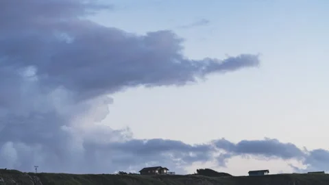 Gray Clouds Passing by Silhouetted Homes Blue Hour Timelapse Stock Footage 203864120