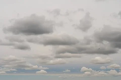 Gray cloudy sky with thick clouds and blue sky peeking through Stock Photos