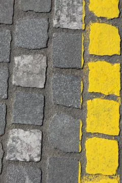 Gray cobblestone background with bright yellow line Stock Photos