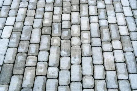 Gray cobblestone paving close up with diagonal arrangement, stone block sur.. Stock Photos