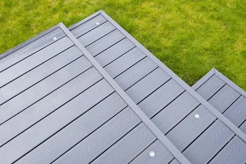 Gray composite deck meets vibrant green grass Stock Photos