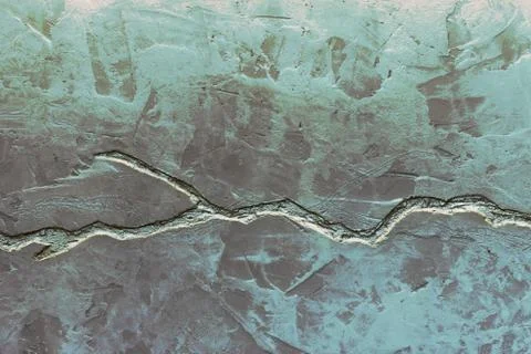 Gray concrete wall texture decorated with blue plaster and deep crack. Stock Photos