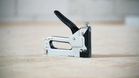 Gray construction stapler made of metal, close-up on a blurred background Stock Footage 238968737