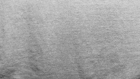 Gray cotton jersey fabric texture rippling gently under warm studio lighting in  Stock Footage 336382019