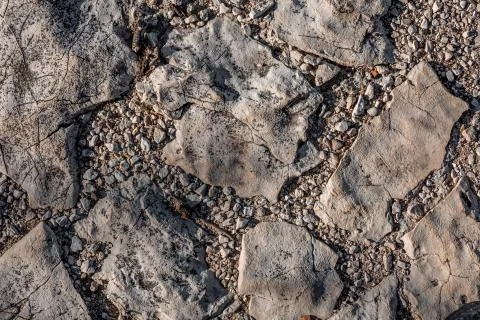 Gray cracked stone texture closeup with small gray pebbles Stock Photos