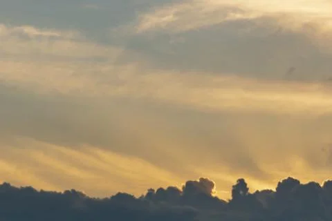 Gray Cumulus clouds in a blue sky with orange light Stock Photos