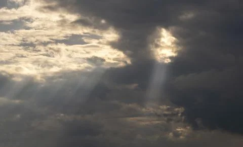 Gray Cumulus clouds in a blue sky with rays of the sun Stock Photos