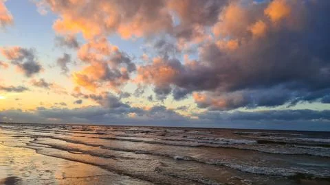 Gray cumulus clouds at sunset and autumn sea with small waves Foto stock