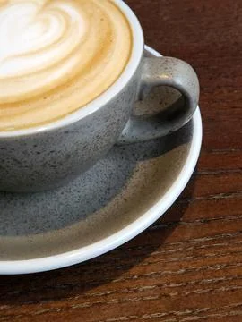 Gray cup of coffee on a brown table. Cup of brewed coffee Stock Photos