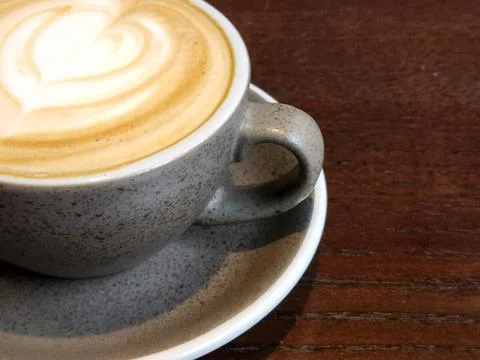 Gray cup of coffee on a brown table. Cup of brewed coffee Foto stock
