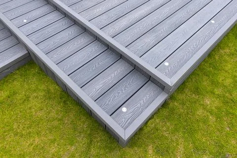 Gray deck planks rest on green grass Foto stock