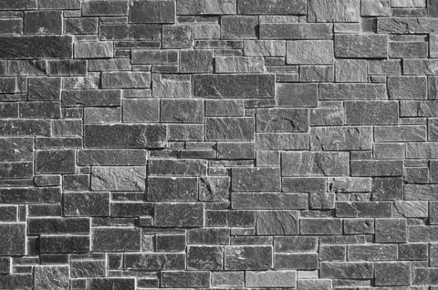 Gray decorative rough stone wall Stock Photos