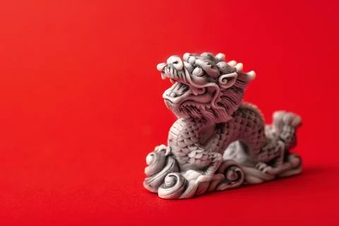 Gray dragon statue on a red background. The symbol of 2024. Stock Photos
