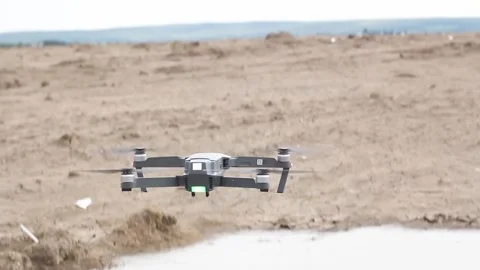 A gray drone takes off above the ground on a cloudy day Stock Footage 134415679