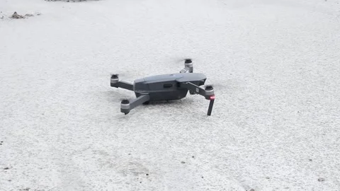 A gray drone takes off above the ground on a cloudy day Stock Footage 134415803