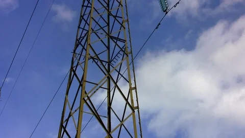 The gray electric pylon shown in a vertical line with white clouds passing by Stock Footage 108838060