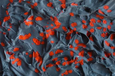 Gray embossed brutal background with bright orange splashes. Foto stock
