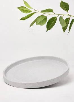 Gray empty decorative plate on white background, product and cosmetic displ.. Stock Photos