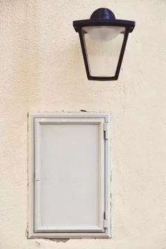 Gray empty metal banner on a light wall. Composition with a lamp and a vintag Stock Photos