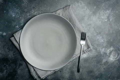 Gray empty plate ceramic with fork on gray stone background. Gray minimalism Stock Photos