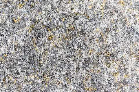 Gray felt texture with interwoven yellow fibers Stock Photos