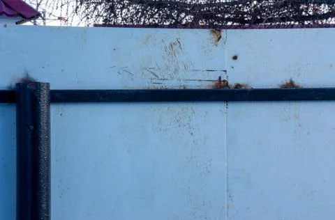 Gray fence with elements of rust and designs. Fotos de archivo