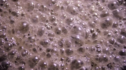 Gray foam with bubbles from the boiling of a thick sticky liquid. A nasty Stock Footage 231346290