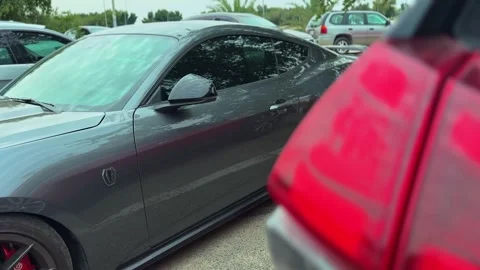 Gray Ford Mustang side profile parked in outdoor lot with blurred red foreground Stock-Footage 333423342