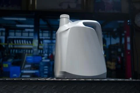 A gray gallon or bottle of engine oil sits on a metal table in a profession.. 库存照片