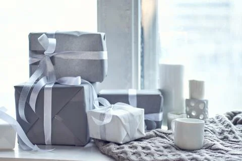 Gray gift boxes with white ribbon on stand Stock Photos