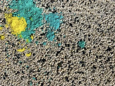 Gray grainy surface background with yellow and blue crushed chalk Stock Photos