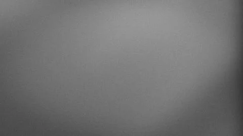Gray grainy textured background with subtle blur and gradient effect in 4K .. Stock Photos