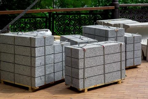 Gray granite border piled in a pile on a pallet for transportation. Stock Photos