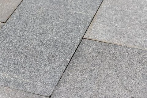 Gray granite paving slabs creating textured outdoor surface Stock Photos