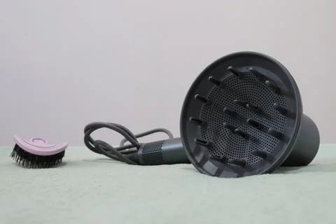 Gray Hair Dryer Diffuser Attachment With Cord Lying Beside Small Pink Cleaning Stock Photos