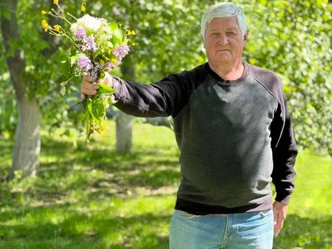 Gray-haired elderly man with  bouquet of flowers Stock-Fotos