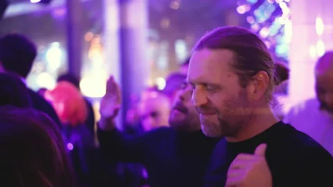 Gray haired German man dances with party people at night club weekend event. Stock Footage 165324641