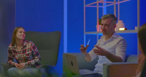 Gray-haired male blogger sits with a laptop and emotionally tells everyone Stock-Footage 174556628