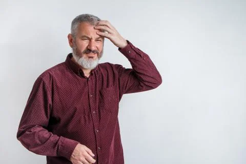 Gray-haired man with a beard suffering from headache desperate and stressed b Foto stock