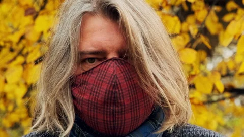 A gray-haired man with a beard takes off his medical mask and laughs hysteric Stock Footage 146751233