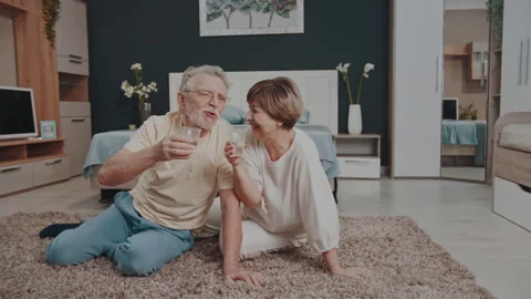 A gray-haired man drinks water from a disposable cup after gym Stock Footage 328025450
