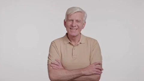 Gray haired man looking at camera and crossing arms over his chest. studio shot Stock Footage 262016671