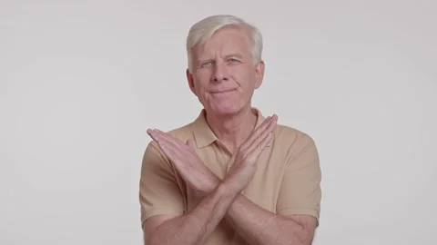 Gray haired man looking at camera and crossing arms over his chest. studio shot Stock Footage 263404193