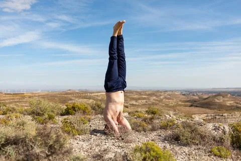 A gray-haired man performs Salamba Shirshasana, or Yoga Headstand, during a yoga Stock-Fotos