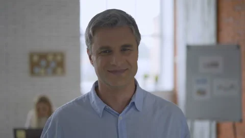 Gray-haired solid top manager man smiles into camera in office, close-up Stock Footage 112877653