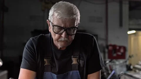 Gray-haired turner with glasses works at the lathe in the factory. Stock Footage 212384745